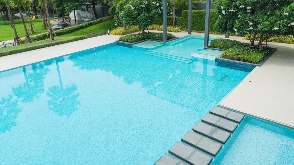 Modern poolside area surrounded by greenery and landscaped plants