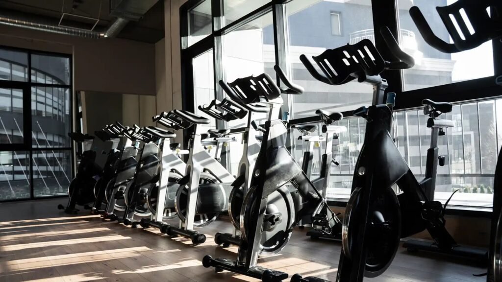 Modern gym interior featuring lined-up cycling machines